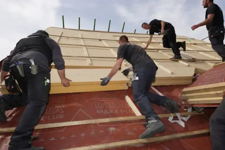 Gude Mitarbeiter dämmen ein Dach.