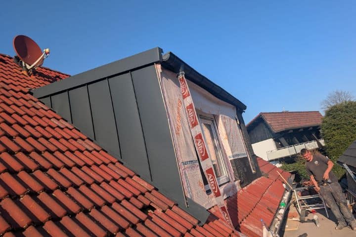 Detailaufnahme: Abdichtungsarbeiten rund um ein neues Dachfenster.